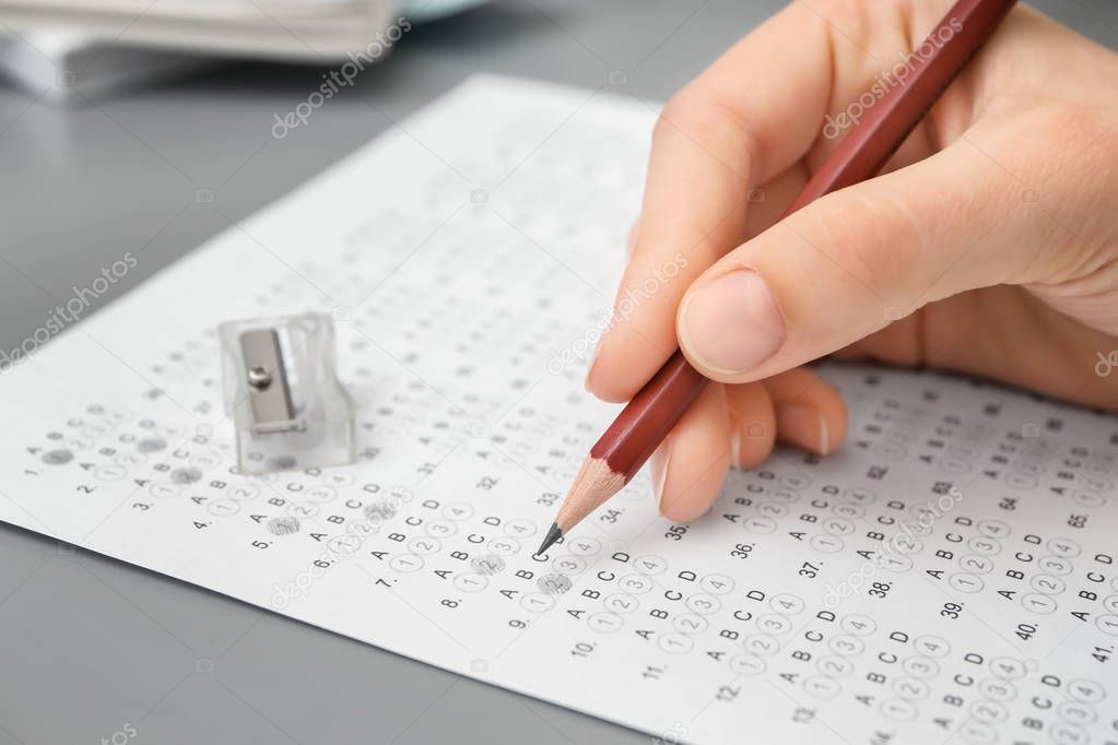 Close up of hand male student passing exam