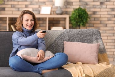 Evde koltukta istirahat ederken TV izlerken kadın