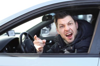 Emotional young man inside car in traffic jam clipart