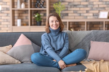 Koltukta evde dinlenirken TV izlerken kadın