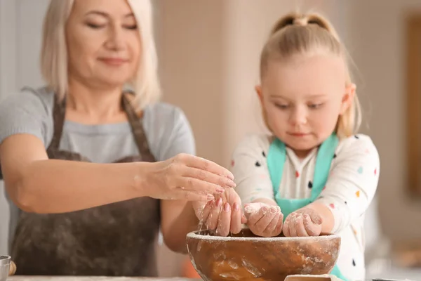 小女孩和她的祖母一起面粉在厨房 — 图库照片