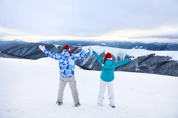Счастливая пара наслаждается красотой снежного горного курорта. Зимние каникулы — стоковое фото