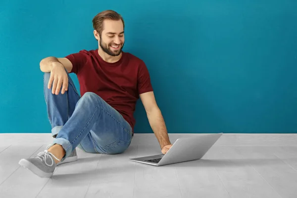 Jonge man met laptop binnenshuis — Stockfoto