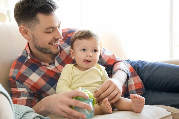 Handsome dad with his little son on sofa at home — Stock Photo, Image