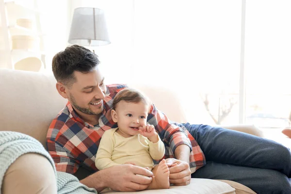 Handsome dad with his little son on sofa at home — Stock Photo, Image