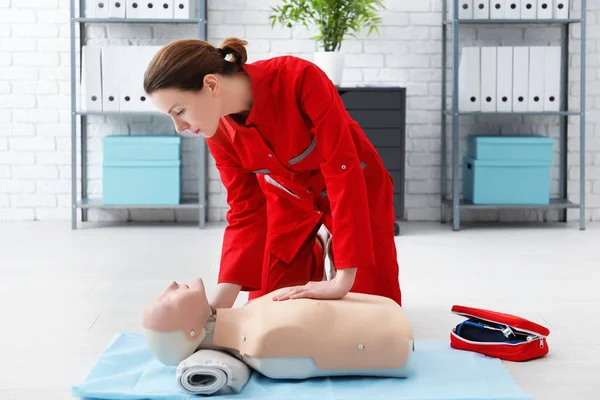 Woman practicing CPR on mannequin at first aid class — Stock Photo, Image
