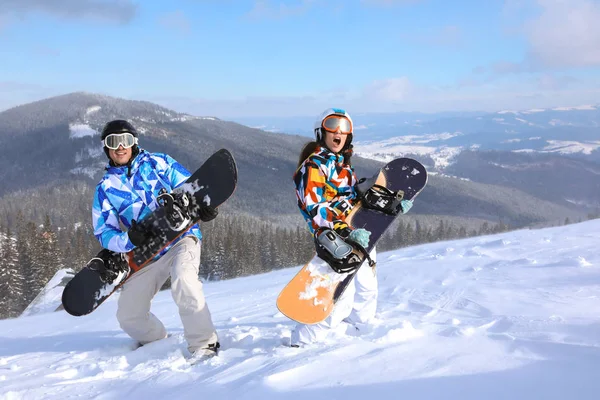 Couple avec snowboards s'amusant sur la piste de ski à la station enneigée. Vacances d'hiver — Photo