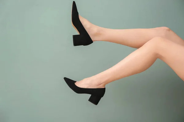 Ноги молодой женщины в элегантной обуви на цветном фоне — стоковое фото