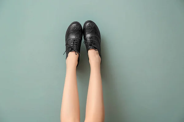 Legs of young woman in stylish casual shoes on color background — Stock Photo, Image