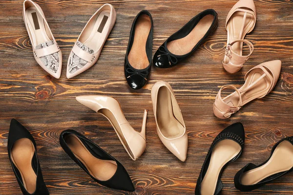 Kvinnliga snygga skor på trä bakgrund, ovanifrån — Stockfoto
