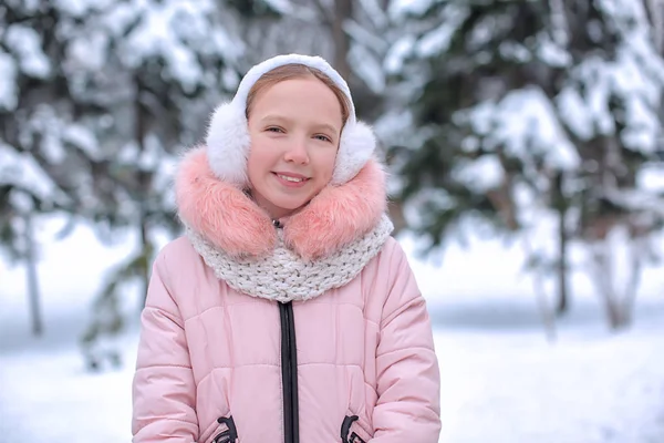 Nettes Mädchen im verschneiten Park im Winterurlaub — Stockfoto