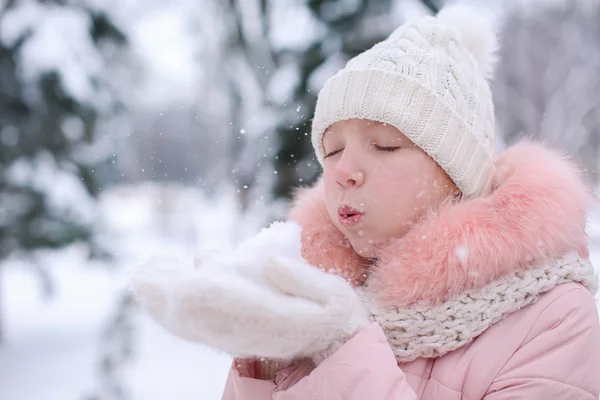 Nettes Mädchen spielt im Winterurlaub mit Schnee im Park — Stockfoto