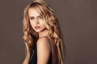 Renk arka plan üzerinde uzun dalgalı saçlı güzel genç kadın