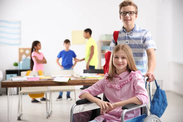 Niño ayudando a chica en silla de ruedas — Foto de Stock