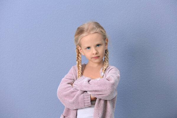 Portrait of emotional little girl on color background
