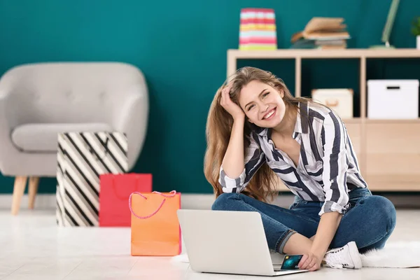 Jovem mulher compras online com cartão de crédito e laptop no chão — Fotografia de Stock