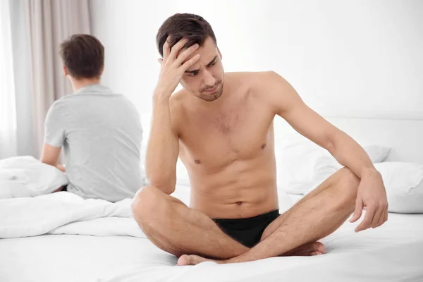 Jonge homo paar met relatieproblemen op bed — Stockfoto