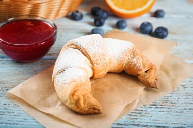 Ahşap masa üzerinde kase reçel ile lezzetli Hilal rulo