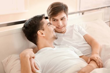 Evde yatakta yatan genç gay çift