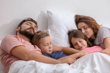 Ebeveynler ve evde yatakta uyuyan çocuklar