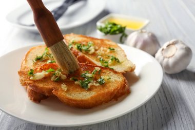 Tereyağı lezzetli ev yapımı sarımsaklı ekmek masada uygulayarak