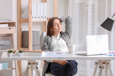 Genç kadın çalışma alanı üzerinde dinlenme