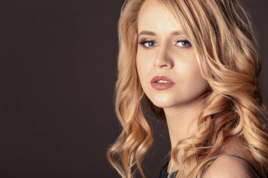 Renk arka plan üzerinde uzun dalgalı saçlı güzel genç kadın