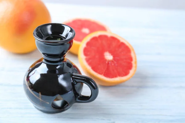 Aroma lamp with citrus fruit on table