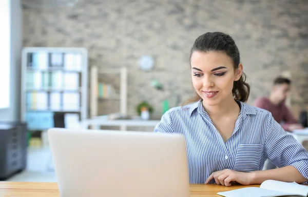 Mujer joven usando el ordenador portátil — Foto de Stock