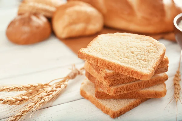 テーブルの上のパンと小麦のスパイクをカットします — ストック写真