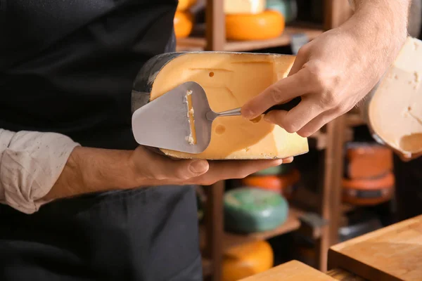 Young worker slicing cheese