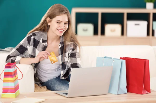 Ung kvinna näthandel med kreditkort och laptop vid bord — Stockfoto