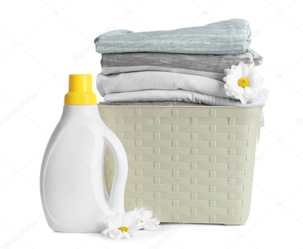 Basket with clothes and laundry detergent on white background