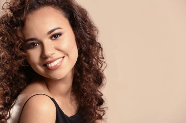 Renk arka plan üzerinde uzun dalgalı saçlı güzel genç Afro-Amerikan kadın