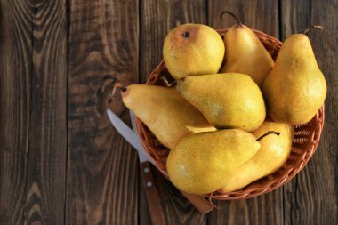 Hasır sepet ile ahşap masa üzerinde taze olgun armut