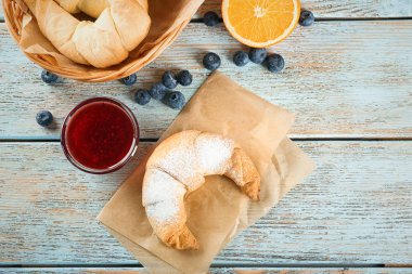 Ahşap masa üzerinde kase reçel ile lezzetli Hilal rulo