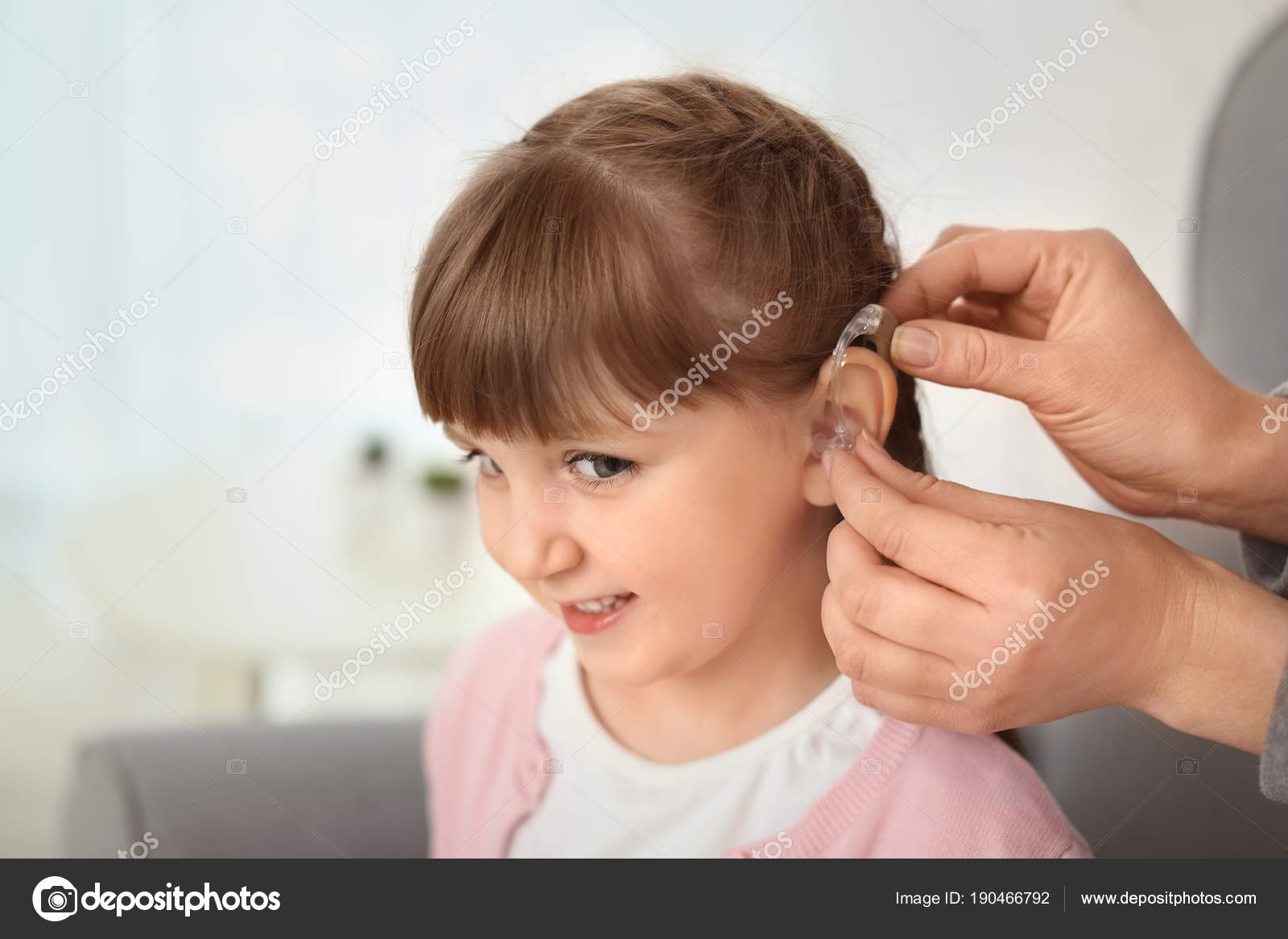 Doctor putting hearing aid in ear Stock Photo by ©belchonock 190466792