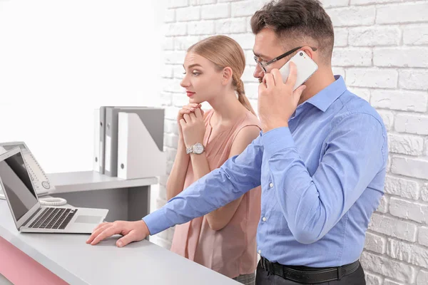 Mannelijke receptioniste met stagiair — Stockfoto