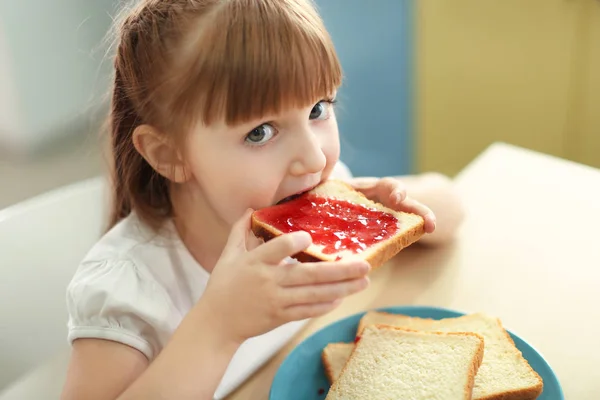 Malá holčička jíst topinky — Stock fotografie