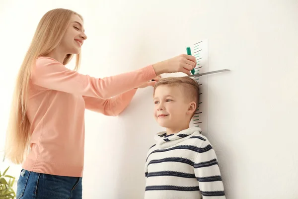 Mujer que mide la altura del niño pequeño —  Fotos de Stock