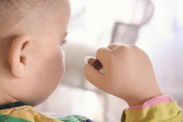 Маленька дівчинка кладе слуховий апарат в її вухо в приміщенні — стокове фото