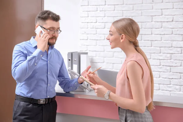 Recepcionista masculino con aprendiz — Foto de Stock