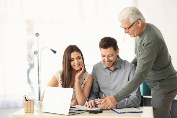 Jong koppel pensioenplan bespreken met consultant in kantoor — Stockfoto