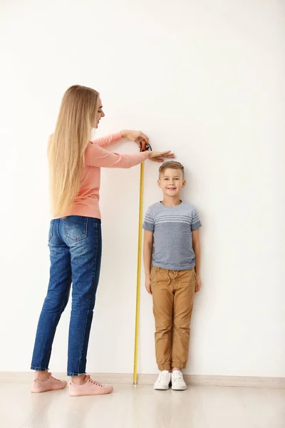 Woman measuring height of little boy — Stock Photo, Image