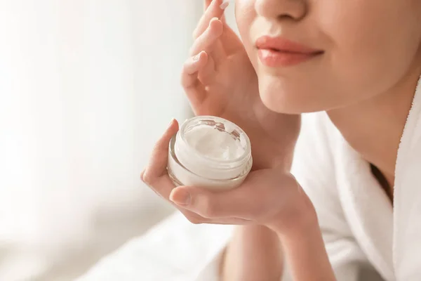 Young woman applying cream