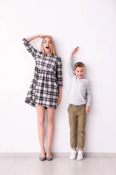 Mulher e menino medindo altura — Fotografia de Stock