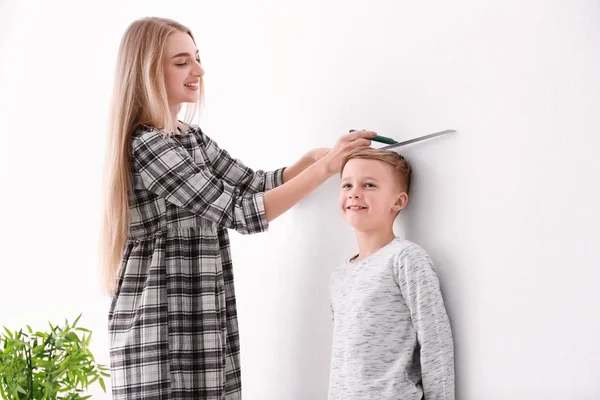 Kadın küçük çocuk yüksekliğini ölçme — Stok fotoğraf