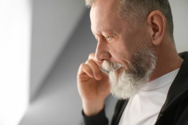 İşyeri ofis cep telefonunda konuşan üst düzey adam