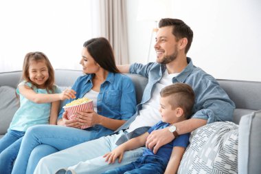 Evde kanepede televizyon izlerken aile