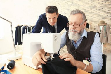 Atelier dikiş makinesi üzerinde çalışan üst düzey terzi